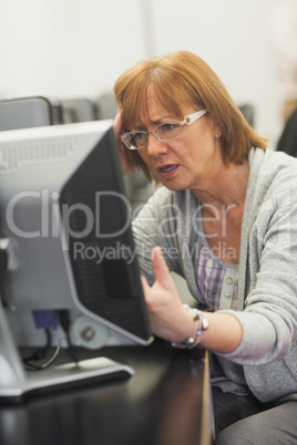 Irritated mature student working on computer