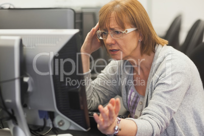 Angry mature student working with computer