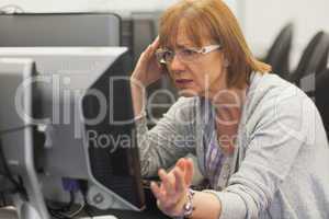 Angry mature student working with computer