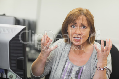 Outraged mature student sitting in front of computer