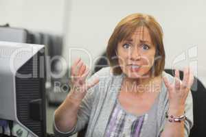 Outraged mature student sitting in front of computer