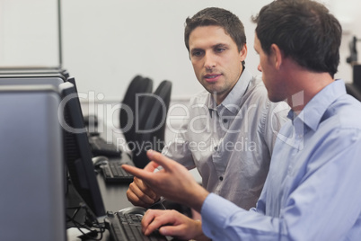 Two attractive men talking in computer class