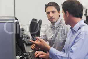 Two attractive men talking in computer class