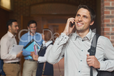 Happy mature student phoning with his smartphone