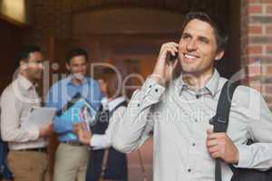 Happy mature student phoning with his smartphone