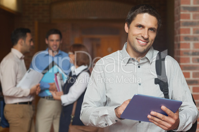 Content male mature student posing in corridor holding his table