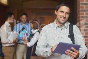 Content male mature student posing in corridor holding his table