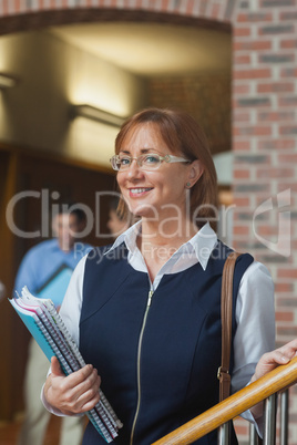 Happy female mature student posing in corridor