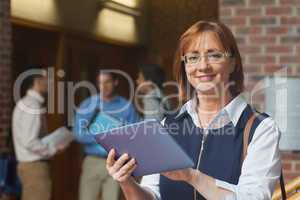 Portrait of cute mature student holding her tablet