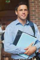 Attractive mature student posing in corridor holding some files