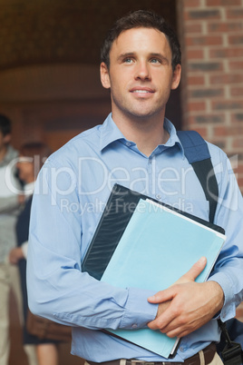 Handsome male mature student posing holding some files