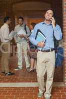 Cheerful handsome mature student phoning with his smartphone