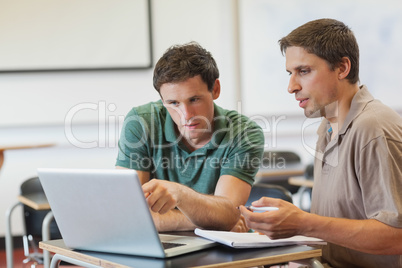 Two concentrated handsome mature students sitting in class