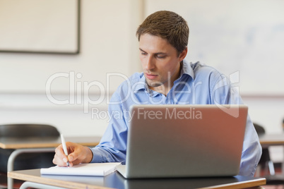 Concentrated male mature student using his notebook for learning