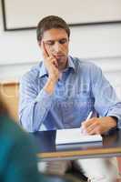 Concentrated mature student sitting in classroom