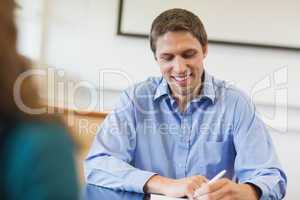 Laughing handsome mature student sitting in classroom
