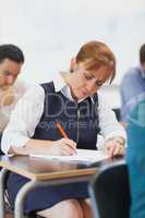 Concentrated female mature student sitting in classroom