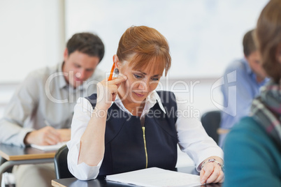 Concentrating female mature woman sitting in classroom