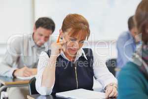 Concentrating female mature woman sitting in classroom