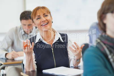 Laughing female mature woman sitting in classroom