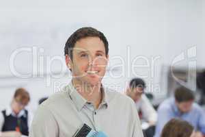 Cute male teacher standing in his classroom