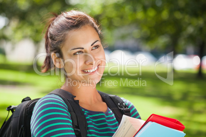 Casual smiling student holding books