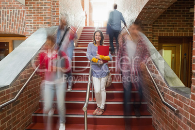 Casual smiling student standing on stairs