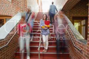 Casual smiling student standing on stairs