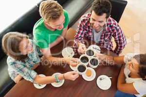 Four happy students having a cup of coffee chatting