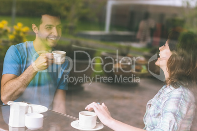 Two students laughing having a cup of coffee