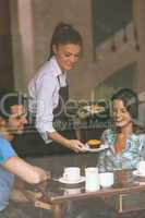 Smiling waitress serving food to a couple