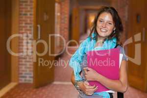 Cute smiling student standing in hallway