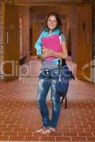 Cute cheerful student standing in hallway
