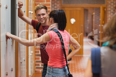 Students leaning against locker flirting