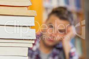 Student studying between piles of books