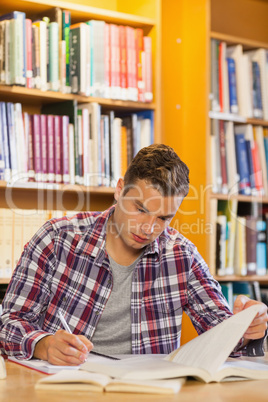 Handsome focused student taking notes