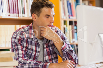 Handsome serious student using computer