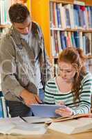 Two smiling students studying together using tablet