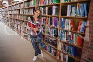 Pretty smiling student holding notebooks