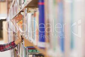 Pretty student taking book out of shelf