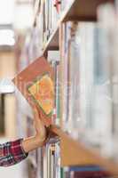 Close up of student taking book out of shelf