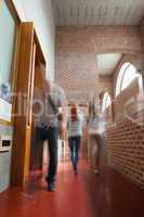 Students walking through hallway away from camera