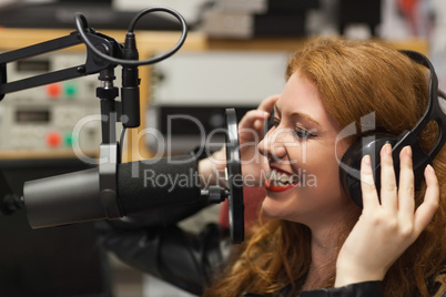 Cheerful beautiful singer recording a song