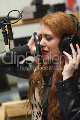 Concentrating beautiful singer recording a song