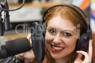 Smiling beautiful singer recording a song