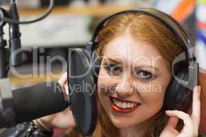 Smiling beautiful singer recording a song