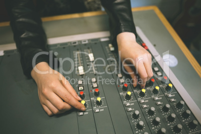 Close up of female hands turning up volume