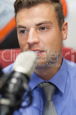 Well dressed concentrating radio host moderating