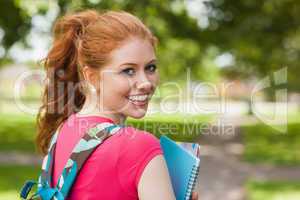 Gorgeous cheerful student holding notebooks