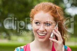 Gorgeous smiling student holding notebooks phoning